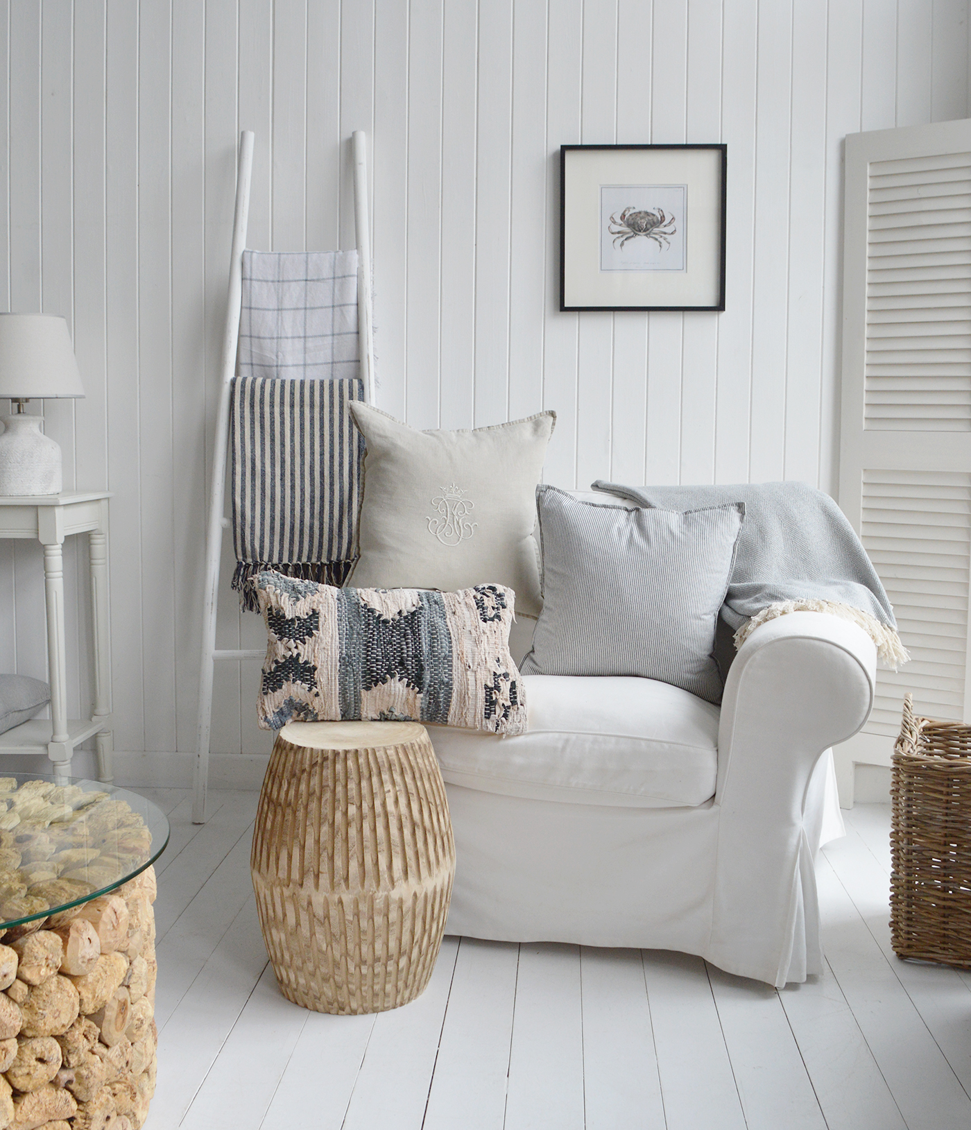 A range of coastal beachhouse furniture including the white blanket ladder and cushions in a Hamptons inspired living room