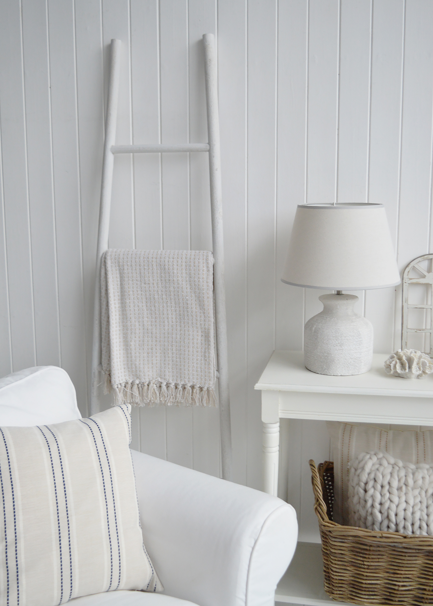 Hamptons inspired styling uses soft neutral palettes, woven baskets and ceramic lighting to create calm, elevated spaces.