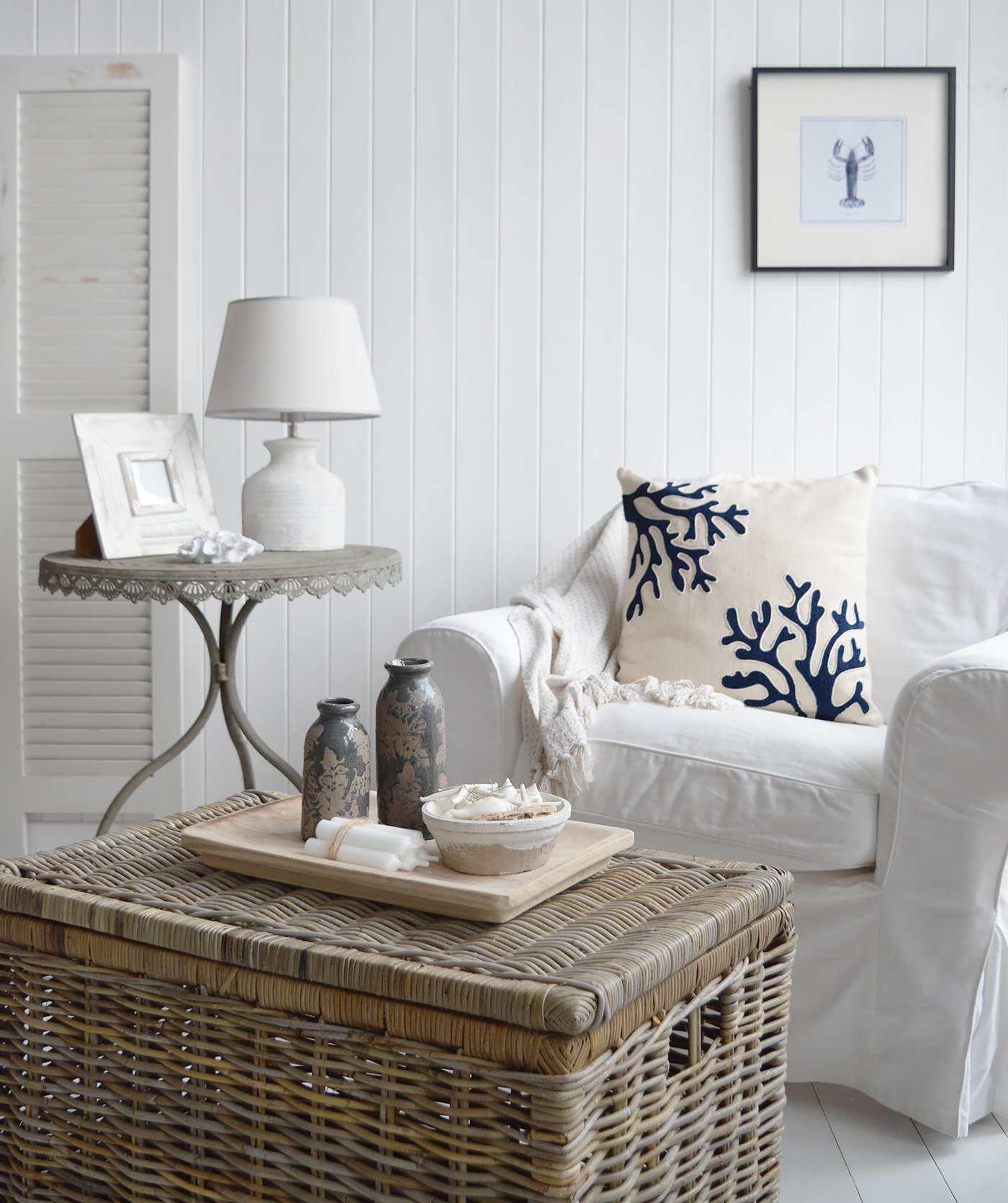 For a coastal Hamptons feel, the Nantucket cushion cover offers a luxurious feel, along with the contrasting rustic basket coffee table stled with vintaged Swanville bottle vases and Chadwick tray