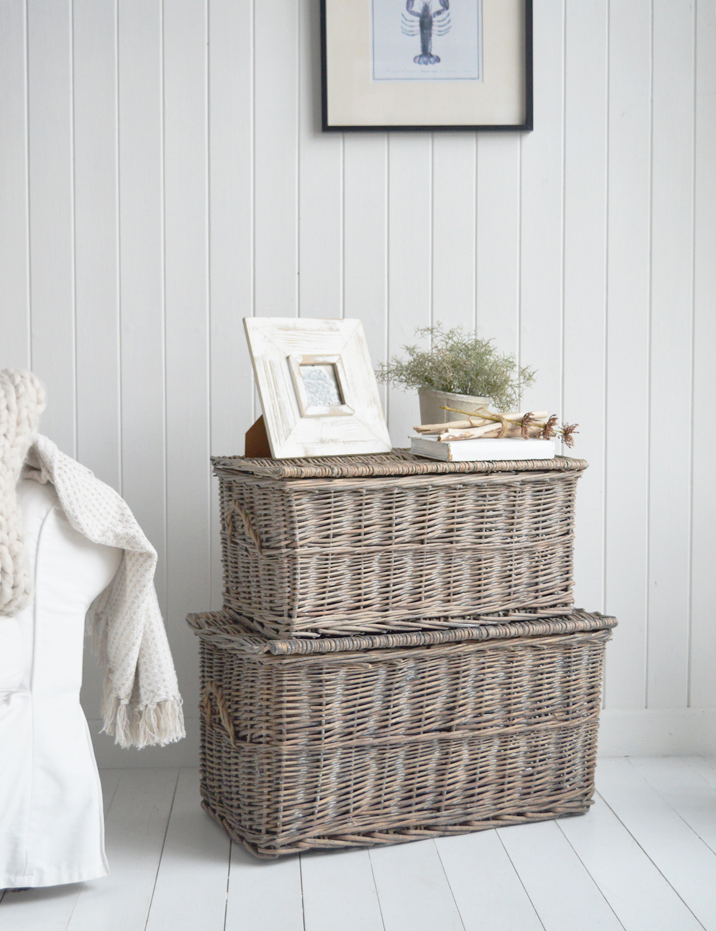 A simple vignette of frame, books and greenery sits perfectly atop the trunk for understated beach house styling.