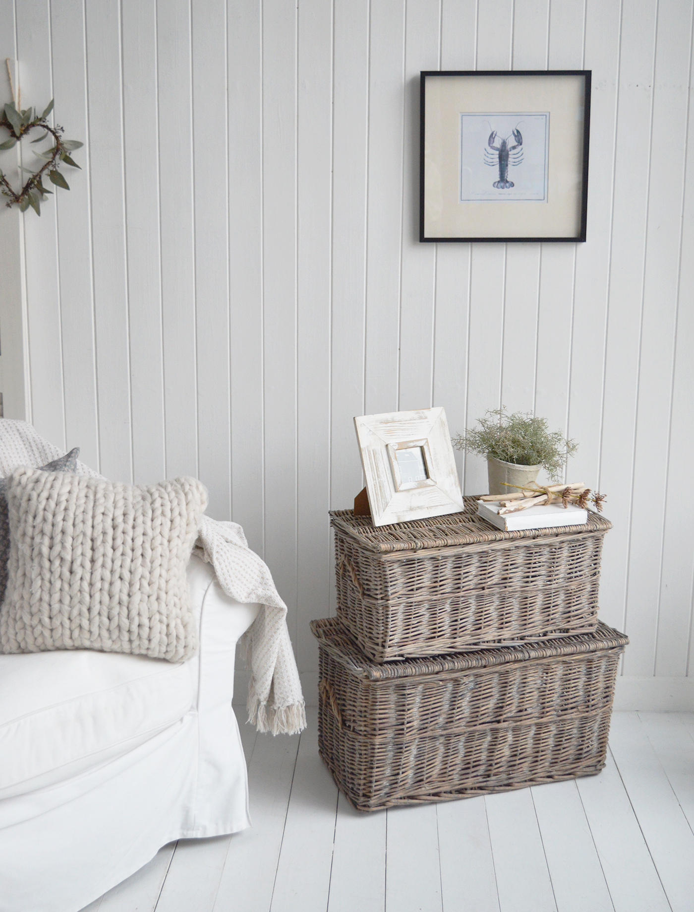 Layered beside white slip-covers and natural linens, the trunks bring depth and warmth to a serene seaside palette.