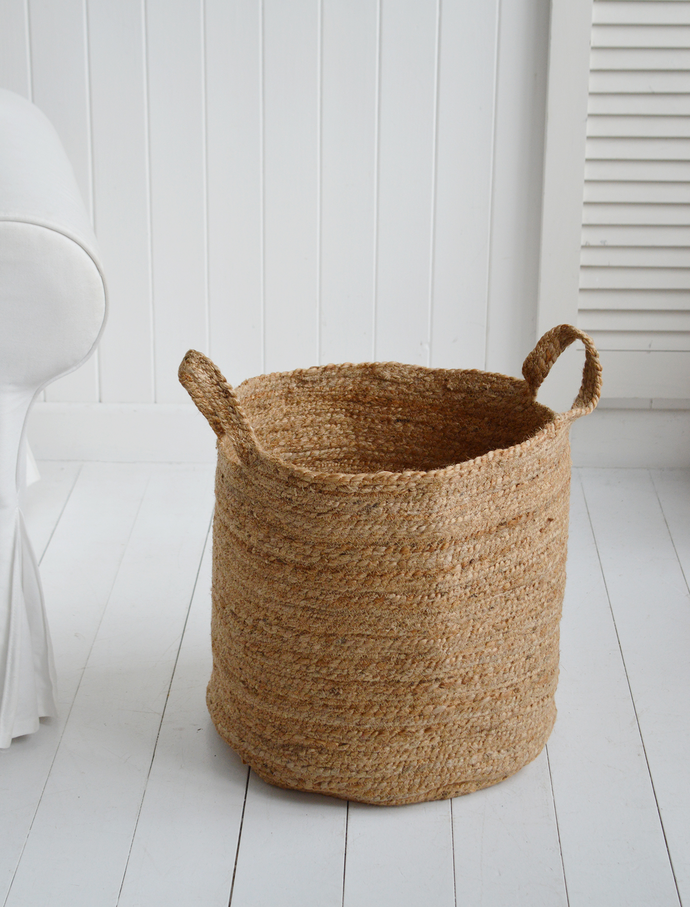 The Fall River basket, a perfect height basket beside a chair in the living room