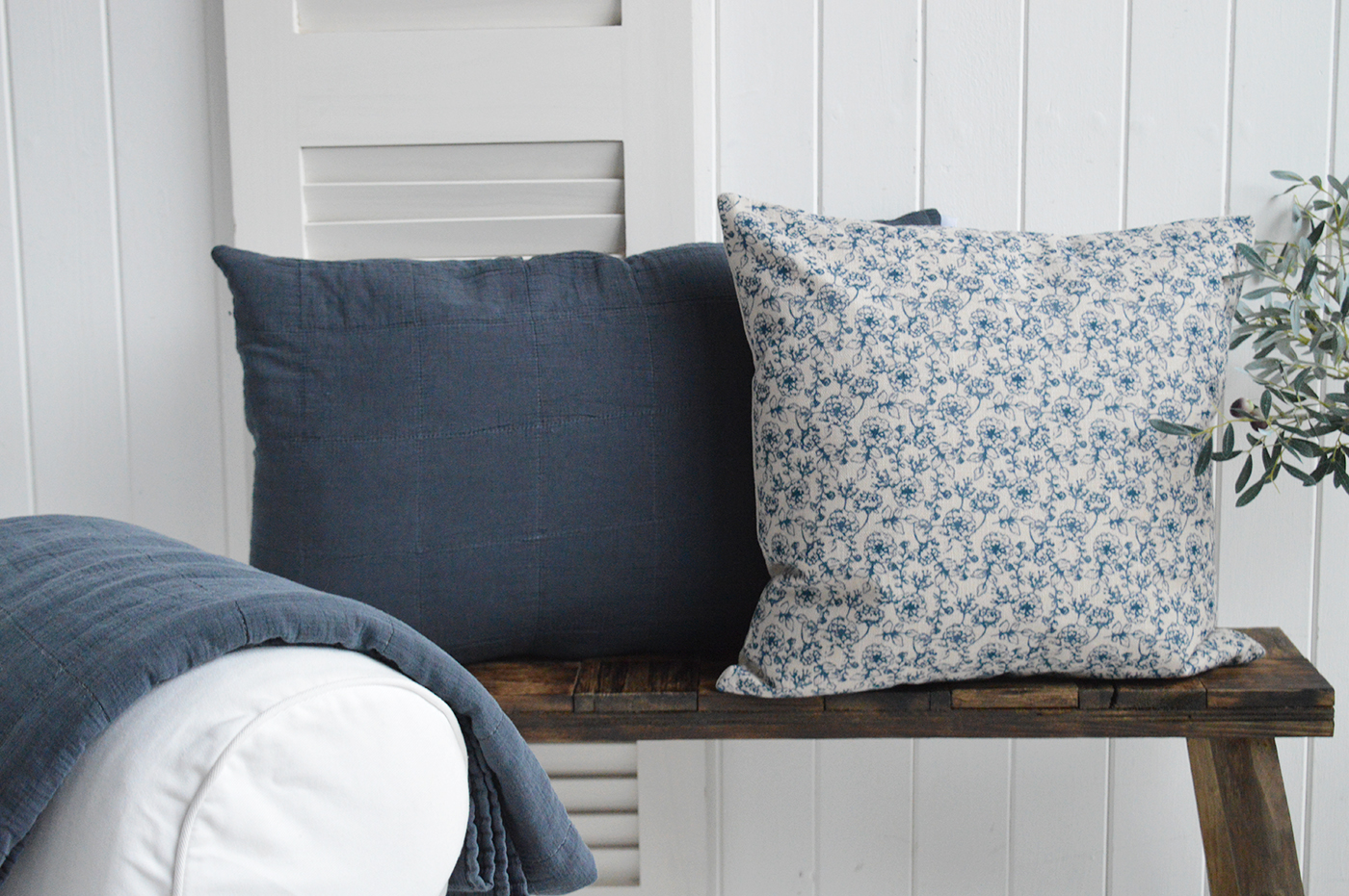 The Lexington floral blue cushion cover shown with a simple plain vany Piermont cushion