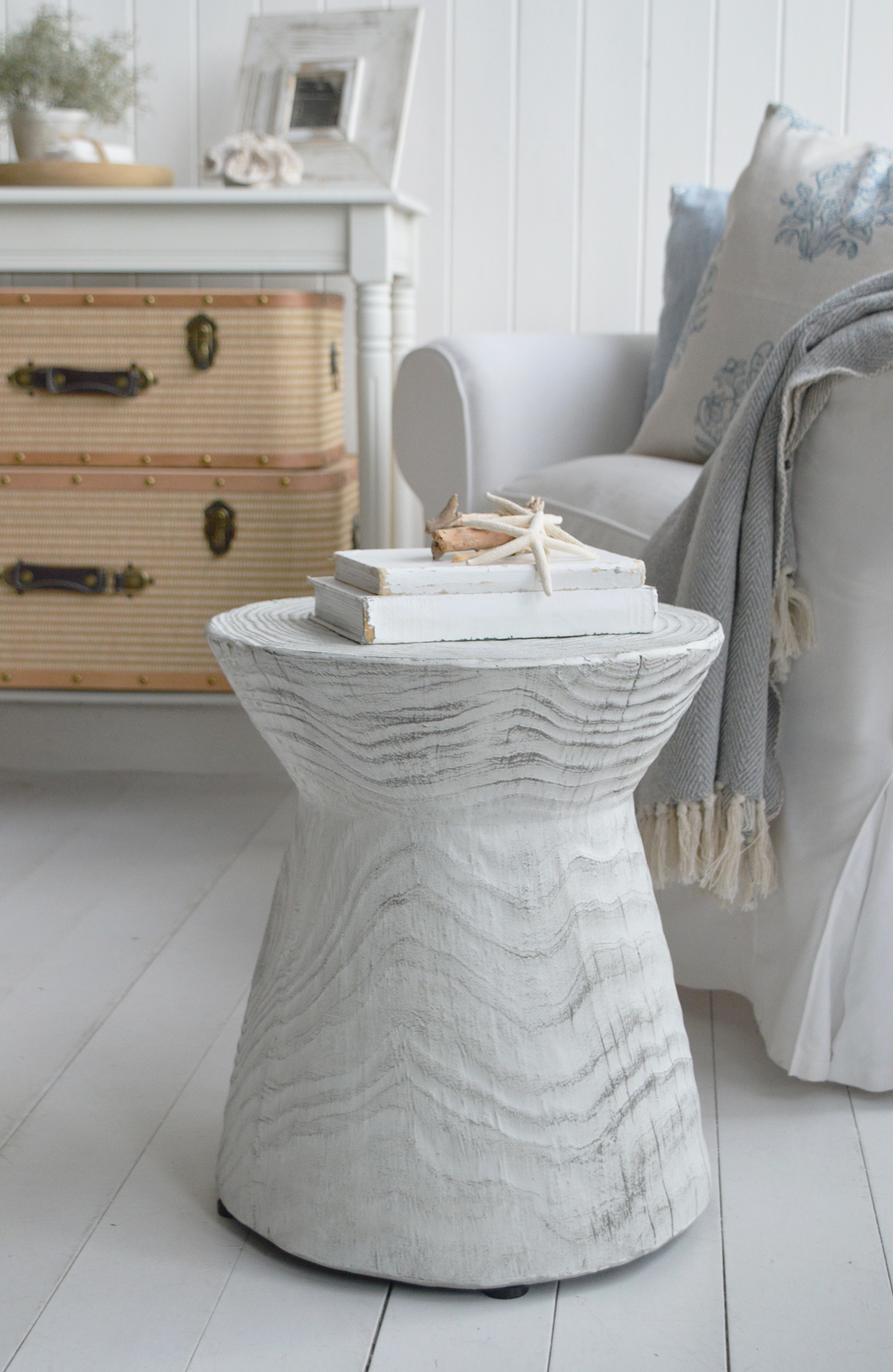 White slipcovered sofas, woven baskets, and rustic side tables are essential pieces in a coastal cottage home.