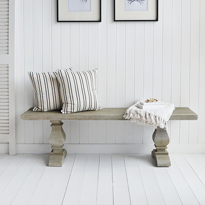 Discover the Sudbury French Grey Bench, crafted from reclaimed wood with rich texture and classic pedestal legs. Perfect for coastal, beach house, or rustic home interiors