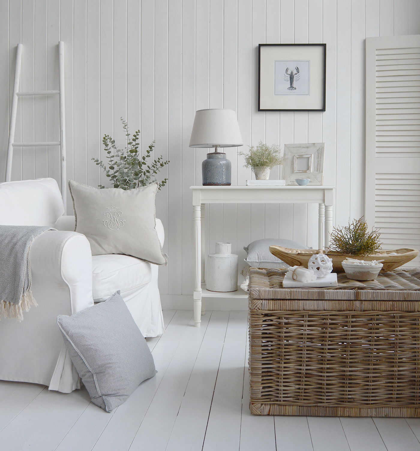 A Coastal New Englands and Hamptons style interior in shades of whites and blue with natural pieces of furniture and homne decor