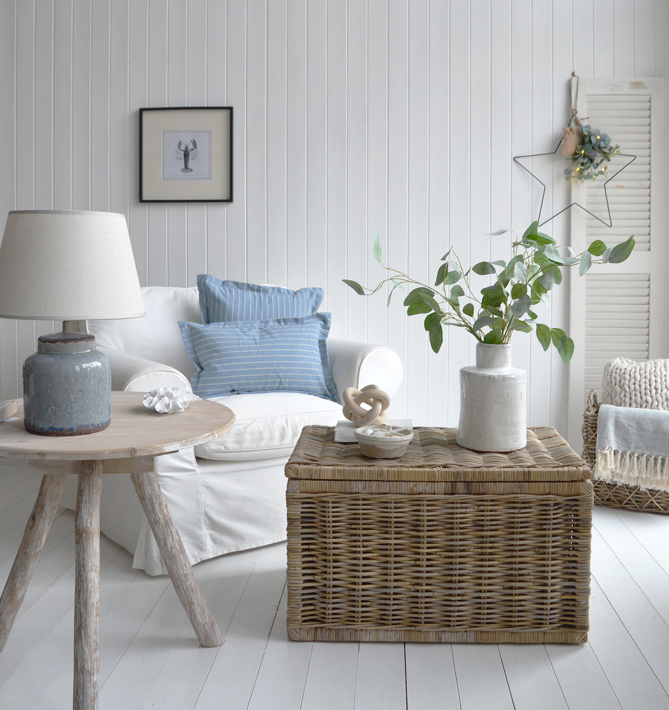 The rattan coffee table in a coastal or farmhouse New England Style living roompale blue lamp and cushionsneutal colours