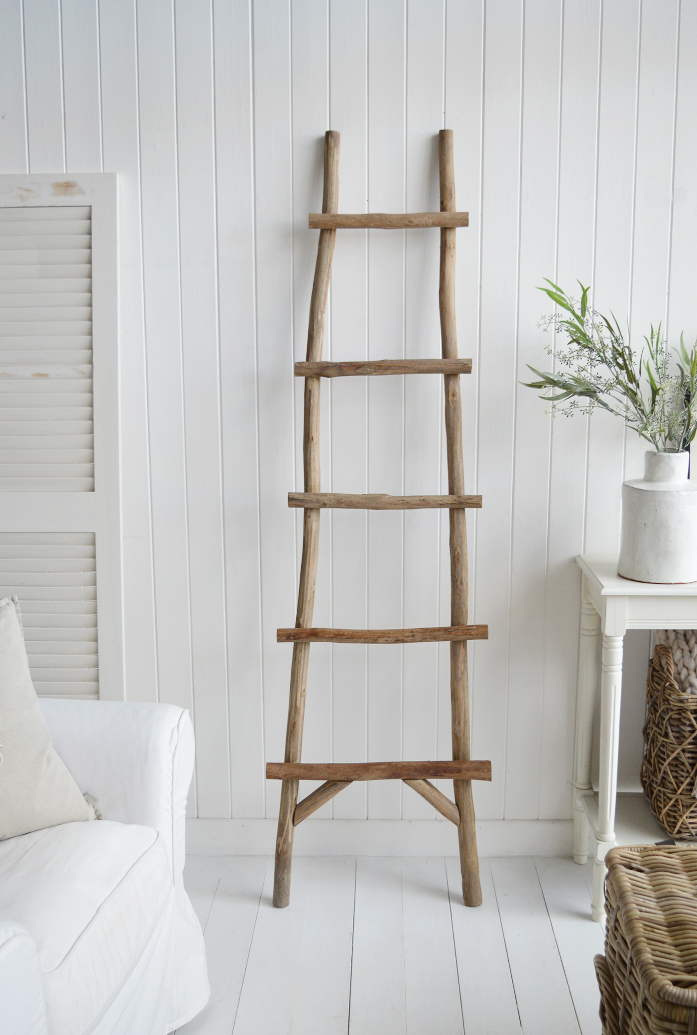 A driftwood ladder is a charming and functional decorative piece that perfectly complements Hamptons, New England coastal, and farmhouse-style interiors. Crafted from naturally weathered driftwood, it exudes a rustic, seaside-inspired aesthetic with soft, sun-bleached tones of gray, beige, and white. The organic texture and irregular shape of each wooden rung highlight its authentic, timeworn appeal, making it a unique statement piece.